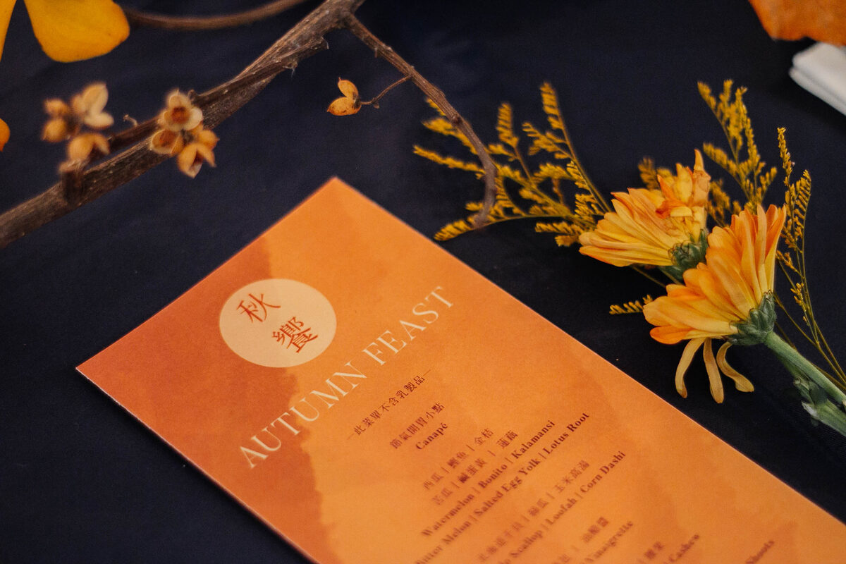 The printed Autumn Feast menu on a set table